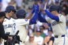 Los Angeles Dodgers' Max Muncy, center, is congratulated by Freddie Freeman, right, and Shohei Ohtani after hitting a three-run home run during the fifth inning of a baseball game Saturday, May 31, 2025, in Los Angeles. (AP Photo/Mark J. Terrill)