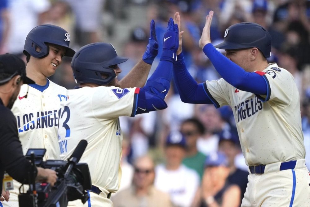 Los Angeles Dodgers' Max Muncy, center, is congratulated by Freddie Freeman, right, and Shohei Ohtani after hitting a three-run home run during the fifth inning of a baseball game Saturday, May 31, 2025, in Los Angeles. (AP Photo/Mark J. Terrill)