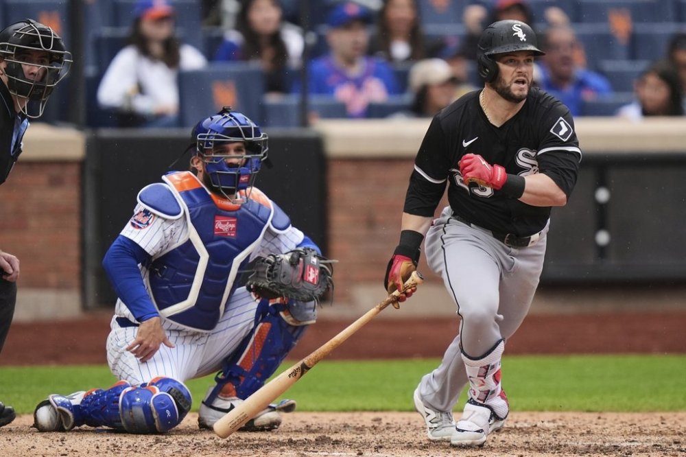 New York Mets catcher Luis Torrens watches as Chicago White Sox's Andrew Benintendi, right, follows through on an RBI triple during the sixth inning of a baseball game Wednesday, May 28, 2025, in New York. (AP Photo/Frank Franklin II)