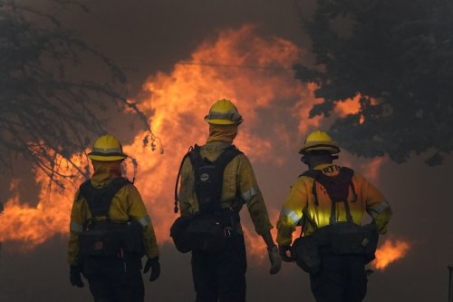 FILE - Members of a Los Angeles County Fire crew make a stand to protect a home from the advancing Bobcat Fire along Cima Mesa Rd. Friday, Sept. 18, 2020, in Juniper Hills, Calif. (AP Photo/Marcio Jose Sanchez, File)