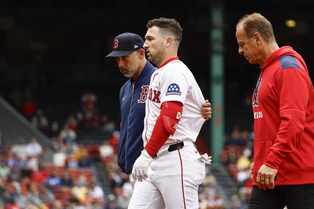 Boston Red Sox's Alex Bregman is led off the field by manager Alex Cora after injuringf himself on a single during the fifth inning against the Baltimore Orioles in the first baseball game of a doubleheader Friday, May 23, 2025, at Fenway Park in Boston. (AP Photo/Winslow Townson)