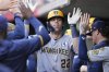 Milwaukee Brewers' Christian Yelich (22) celebrates with teammates after hitting a solo home run during the third inning of a baseball game against the Cincinnati Reds, Monday, June 2, 2025, in Cincinnati. (AP Photo/Jeff Dean)