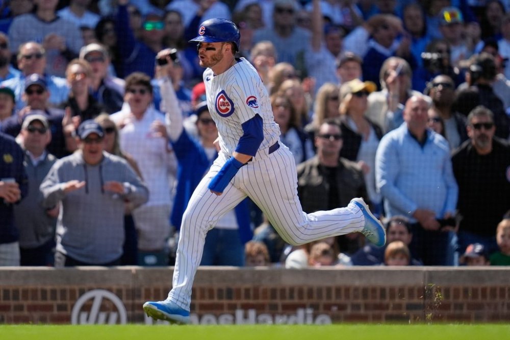 Chicago Cubs' Happ runs home to score on a double by designated hitter Seiya Suzuki (27) during the eighth inning of a baseball game against the Cincinnati Reds, Saturday, May 31, 2025, in Chicago. (AP Photo/Erin Hooley)