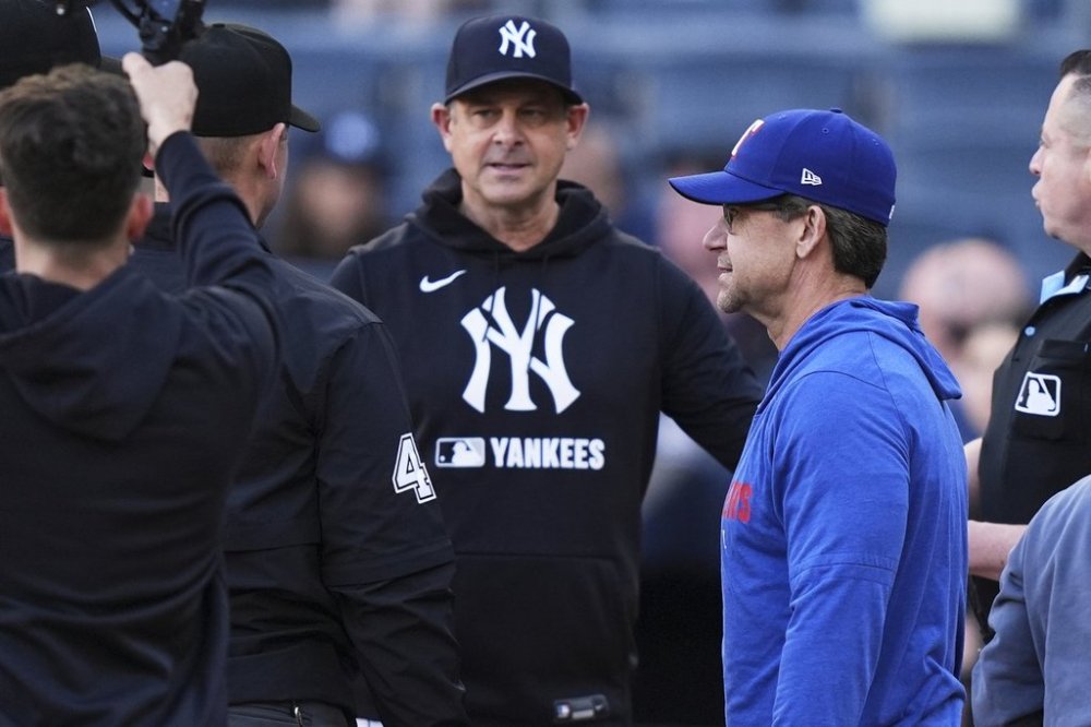 Texas Rangers hitting coach Bret Boone, right, and New York Yankees manager Aaron Boone talk to the officials before a baseball game Tuesday, May 20, 2025, in New York. (AP Photo/Frank Franklin II)