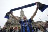 Inter Milan fan Andrea Trebbi holds up a team scarf in front of the Neues Rathaus Town Hall, Thursday, May 29, 2025, ahead of the Champions League final soccer match between Paris Saint-Germain and Inter Milan in Munich, Germany. (AP Photo/Luca Bruno)
