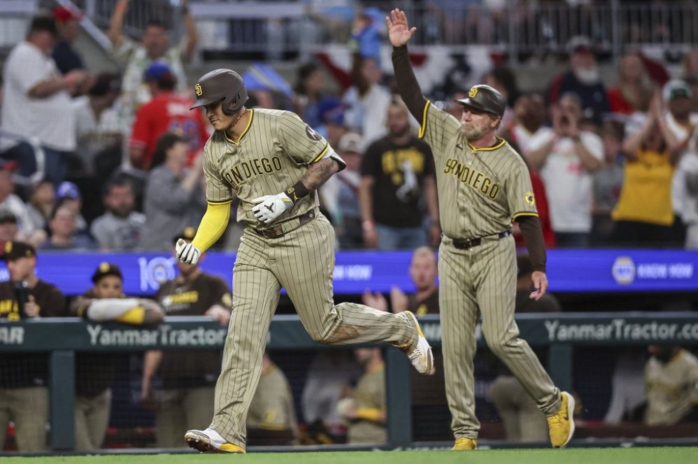 San Diego Padres' Manny Machado, left, rounds third base after hitting a home run in the ninth inning of a baseball game against the Atlanta Braves, Friday, May 23, 2025, in Atlanta. (AP Photo/Colin Hubbard)