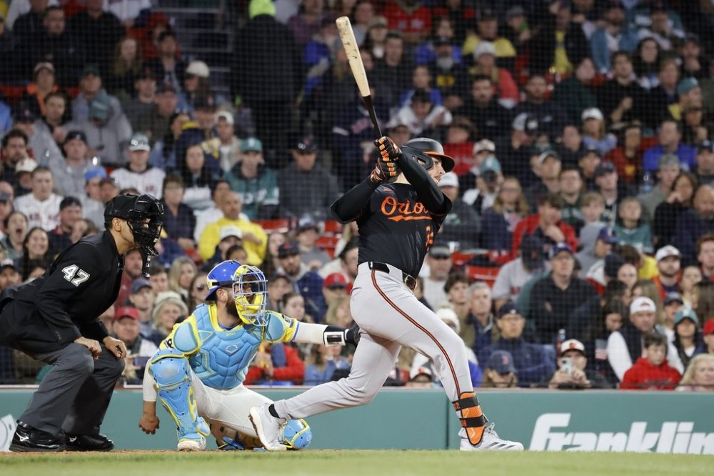 Baltimore Orioles' Ryan O'Hearn, right, hits an RBI single, scoring Gunnar Henderson, during the eighth inning of the second baseball game of a doubleheader against the Boston Red Sox, Saturday, May 24, 2025, at Fenway Park in Boston. (AP Photo/Mary Schwalm)