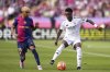 Real Madrid's Vinicius Junior, right, and Barcelona's Lamine Yamal compete for the ball during the Spanish La Liga soccer match between Barcelona and Real Madrid at the Lluis Companys Olympic Stadium in Barcelona, Spain, Sunday, May 11, 2025. (AP Photo/Jose Breton)