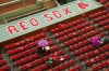 Fans sit behind the Boston Red Sox dugout during a rain delay before the second baseball game of a doubleheader against the Baltimore Orioles, Friday, May 23, 2025, at Fenway Park in Boston. (AP Photo/Winslow Townson)