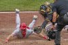 Cincinnati Reds' Spencer Steer, left, is tagged out by Pittsburgh Pirates catcher Henry Davis, center, attempting to score on a double by Tyler Stephenson during the sixth inning of a baseball game in Pittsburgh, Wednesday, May 21, 2025. (AP Photo/Gene J. Puskar)
