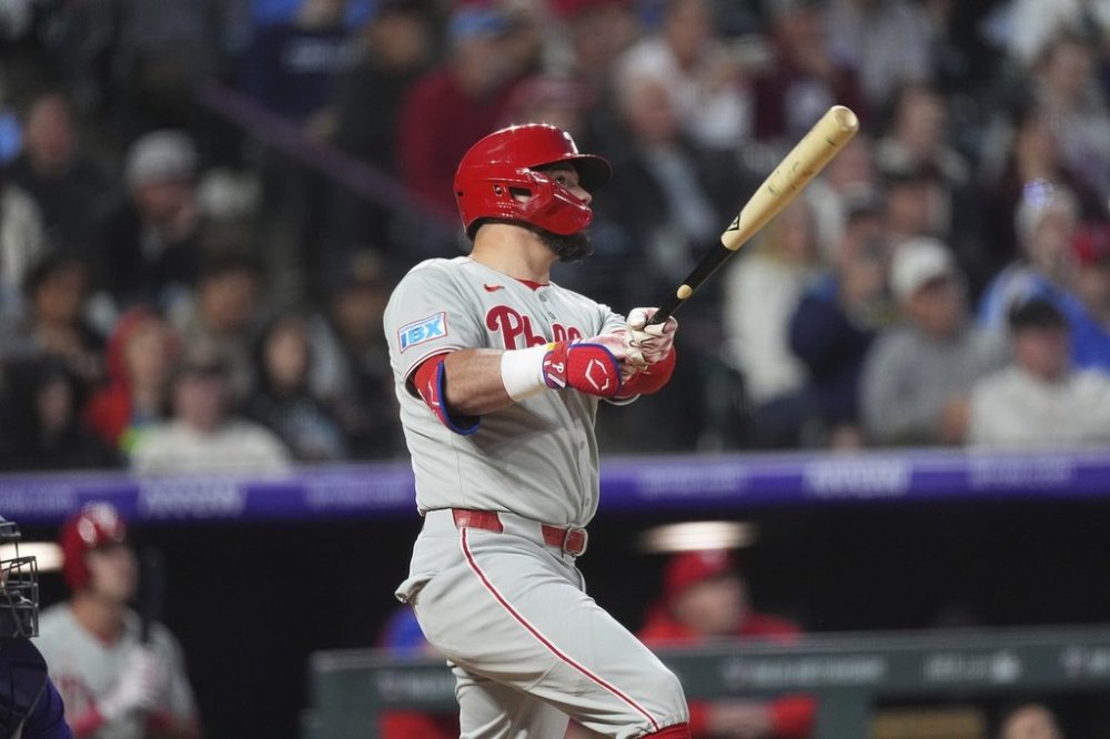 Philadelphia Phillies' Kyle Schwarber follows the flight of his solo home run off Colorado Rockies relief pitcher Ryan Rolison in the seventh inning of a baseball game, Tuesday, May 20, 2025, in Denver. (AP Photo/David Zalubowski)