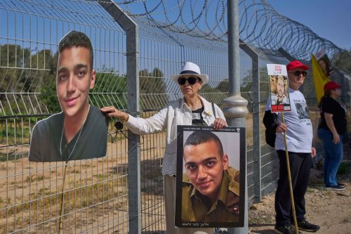 FILE - Varda Ben Baruch holds a picture of her grandson Edan Alexander, who is held hostage in Gaza, gathers with other families to call out on loudspeakers in hopes that their loved ones will hear them, near the Gaza border in Kibbutz Nir Oz, southern Israel, April 20, 2025. (AP Photo/Ohad Zwigenberg, File)