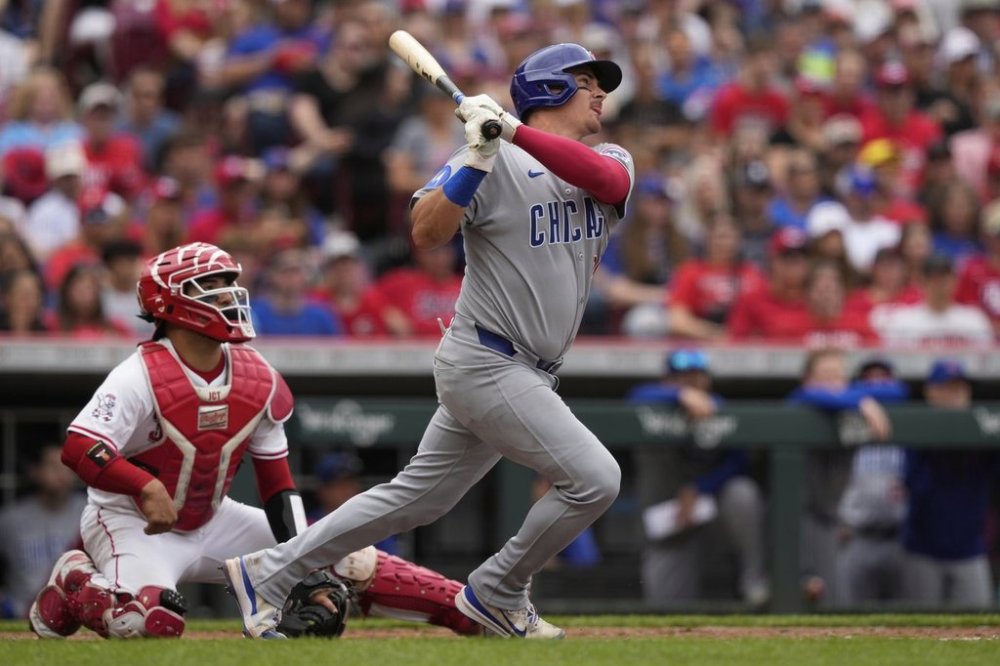 Chicago Cubs' Reese McGuire hits a solo home run as Cincinnati Reds catcher Jose Trevino looks on in the second inning of a baseball game, Sunday, May 25, 2025, in Cincinnati. (AP Photo/Carolyn Kaster)