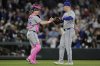 Toronto Blue Jays pitcher Braydon Fisher, right, shakes hands with Tyler Heineman, left, after a win over the Seattle Mariners in a baseball game Sunday, May 11, 2025, in Seattle. (AP Photo/John Froschauer)