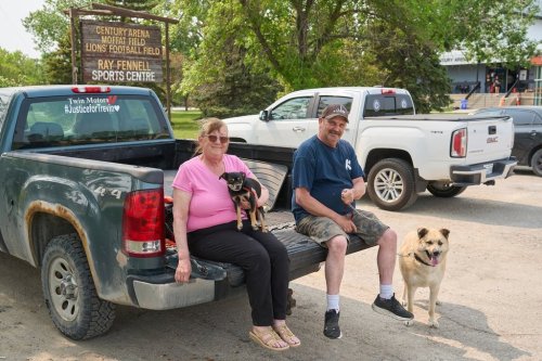 Jennifer Chretien and her husband Rob Burroughs sit with their dogs Taco and Gunner on their truck outside of a reception centre for evacuees of the wildfires in northern Manitoba at the Century Arena in Winnipeg, Thursday, May 29, 2025. The couple drove from Flin Flon as evacuations were ordered, and will be spending the night at the community centre. THE CANADIAN PRESS/David Lipnowski