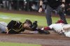 Pittsburgh Pirates catcher Joey Bart, left, tags out Arizona Diamondbacks' Lourdes Gurriel Jr. at home plate during the first inning of a baseball game Tuesday, May 27, 2025, in Phoenix. (AP Photo/Ross D. Franklin)