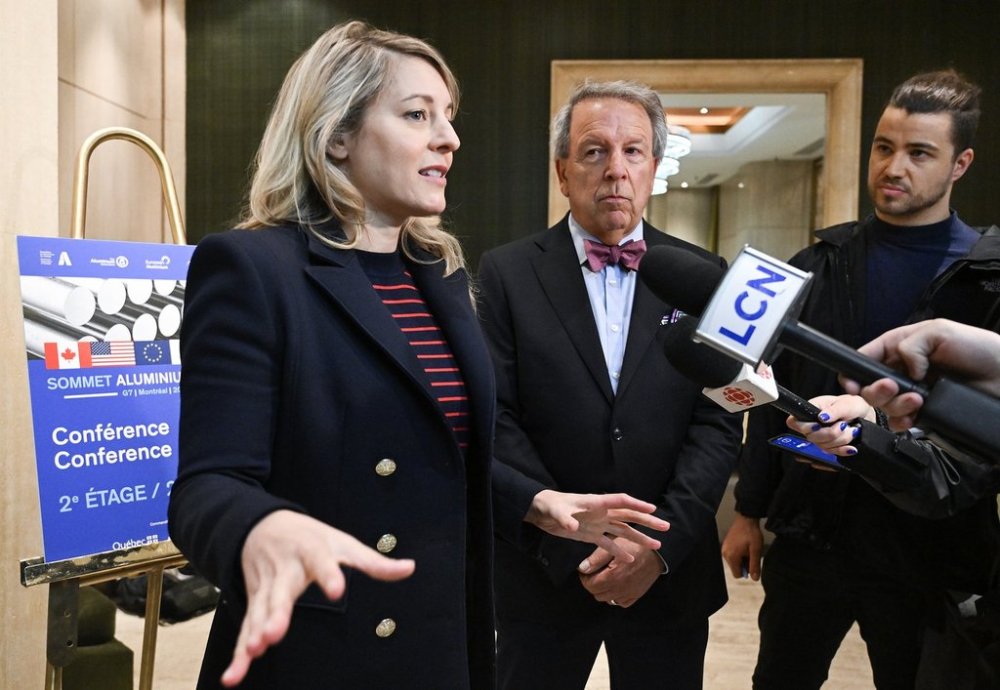 Jean Simard, president and CEO of the Aluminium Association of Canada, centre, looks on as Industry Minister Mélanie Joly speaks to the media after arriving for a meeting in Montreal on Sunday, June 1, 2025. THE CANADIAN PRESS/Graham Hughes