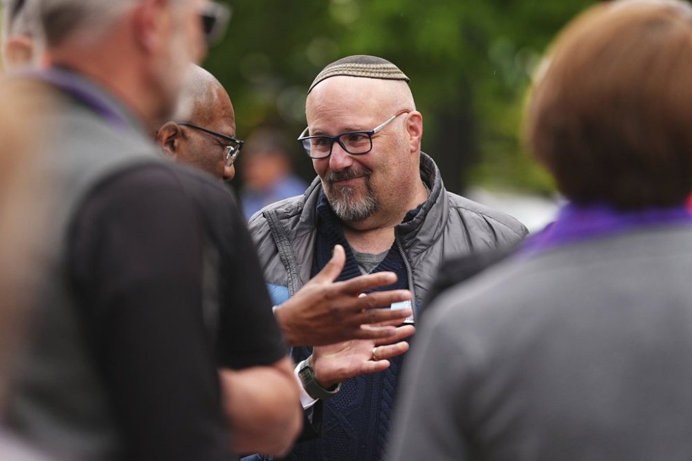 Rabbi Fred Greene of Congregation Har HaShem in Boulder, Colo., talks with fellow celebrants of a tribute at a makeshift memorial for victims of an attack outside of the Boulder County, Colo., courthouse Tuesday, June 3, 2025, in Boulder, Colo. (AP Photo/David Zalubowski)