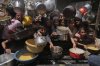 Palestinians struggle to get donated food at a community kitchen in Jabalia, northern Gaza Strip, Monday, May 19, 2025. (AP Photo/Jehad Alshrafi)