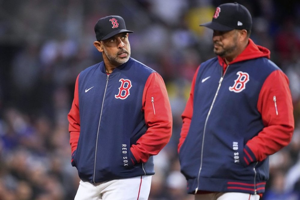 Boston Red Sox manager Alex Cora, left, walks back to the dugout with bench coach Ramon Vazquez after being ejected by home plate umpire Mike Estabrook during the third inning of a baseball game against the New York Mets at Fenway Park, Tuesday, May 20, 2025, in Boston. (AP Photo/Charles Krupa)