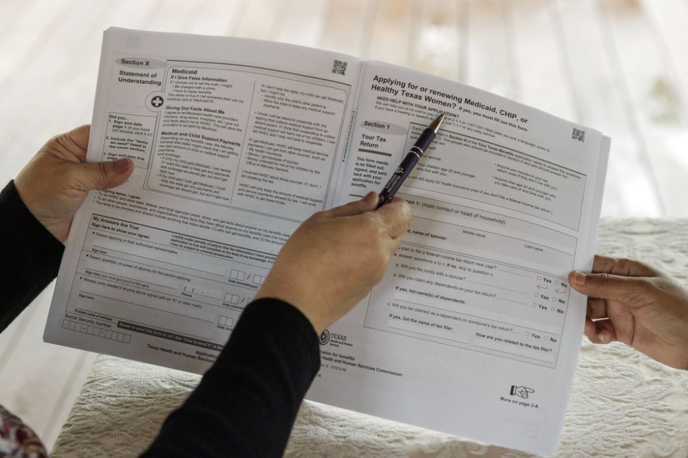 FILE - Children's Defense Fund Program Director Graciela Camarena assists Lucia Salazar with filling out Medicaid and SNAP application forms for her family in Pharr, Texas, Nov. 13, 2023. (AP Photo/Michael Gonzalez, File)