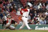Boston Red Sox's Rafael Devers, right, follows through on a grand slam against the Baltimore Orioles during the eighth inning in the first baseball game of a doubleheader Friday, May 23, 2025, at Fenway Park in Boston. (AP Photo/Winslow Townson)