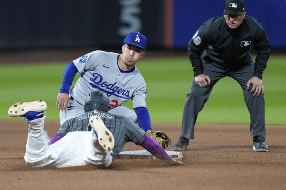Los Angeles Dodgers second baseman Tommy Edman, top left, catches New York Mets' Starling Marte, bottom left, stealing second base during the seventh inning of a baseball game, Sunday, May 25, 2025, in New York. (AP Photo/Seth Wenig)