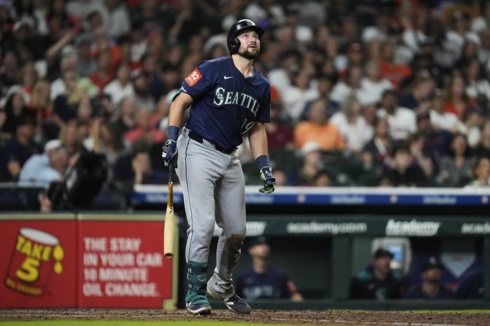 Seattle Mariners' Cal Raleigh watches his home run during the seventh inning of a baseball game against the Houston Astros in Houston, Friday, May 23, 2025. Julio Rodriguez also scored. (AP Photo/Ashley Landis)