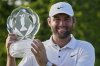 Scottie Scheffler holds the trophy after winning the Memorial golf tournament Sunday, June 1, 2025, in Dublin, Ohio. (AP Photo/Sue Ogrocki)