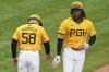 Pittsburgh Pirates' Oneil Cruz, right, celebrates with third base coach Mike Rabelo (58) as he rounds third after hitting a solo home run off Milwaukee Brewers pitcher Freddy Peralta during the third inning of a baseball game in Pittsburgh, Friday, May 23, 2025. (AP Photo/Gene J. Puskar)