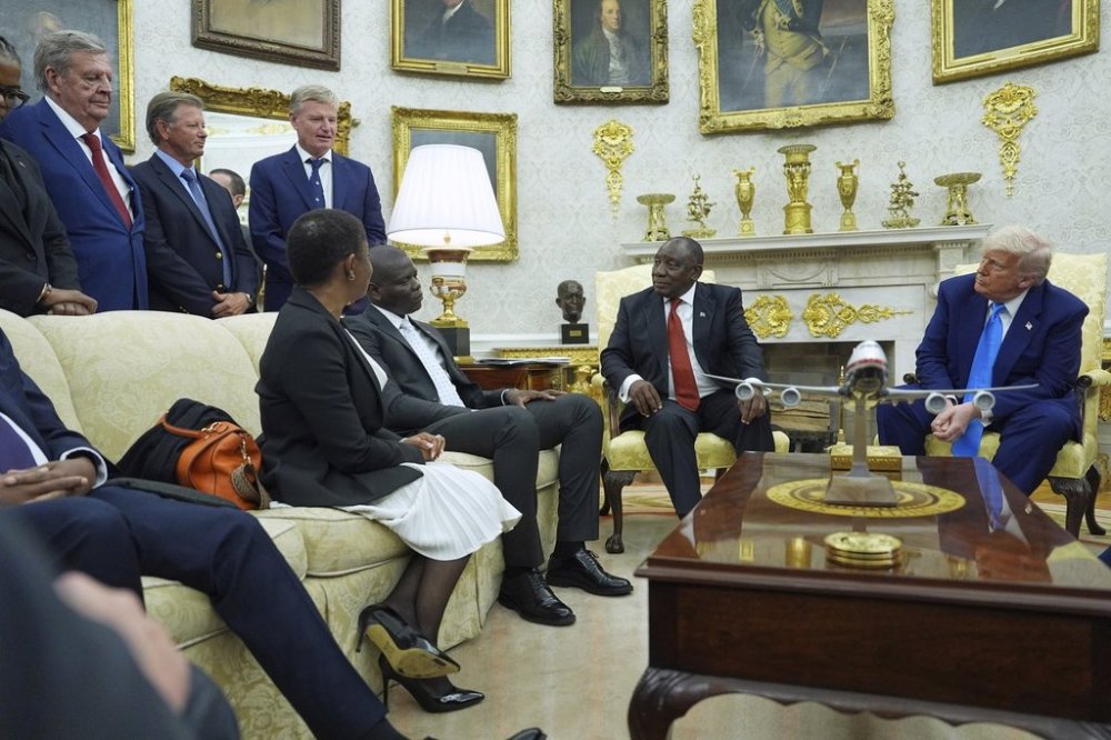 President Donald Trump meets South African President Cyril Ramaphosa in the Oval Office of the White House, Wednesday, May 21, 2025, in Washington, as South African businessman Johann Rupert, looks on, upper left. (AP Photo/Evan Vucci)