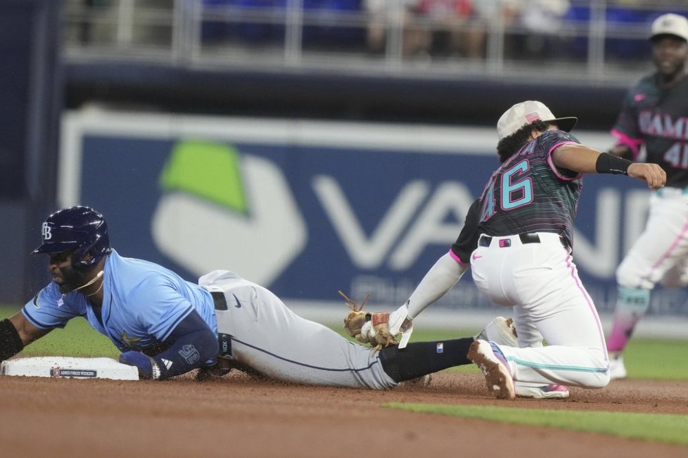 Tampa Bay Rays' Yandy Díaz (2) as Miami Marlins short stop Javier Sanoja (46) is late with the tags during the first inning of a baseball game, Saturday, May 17, 2025, in Miami. (AP Photo/Marta Lavandier)