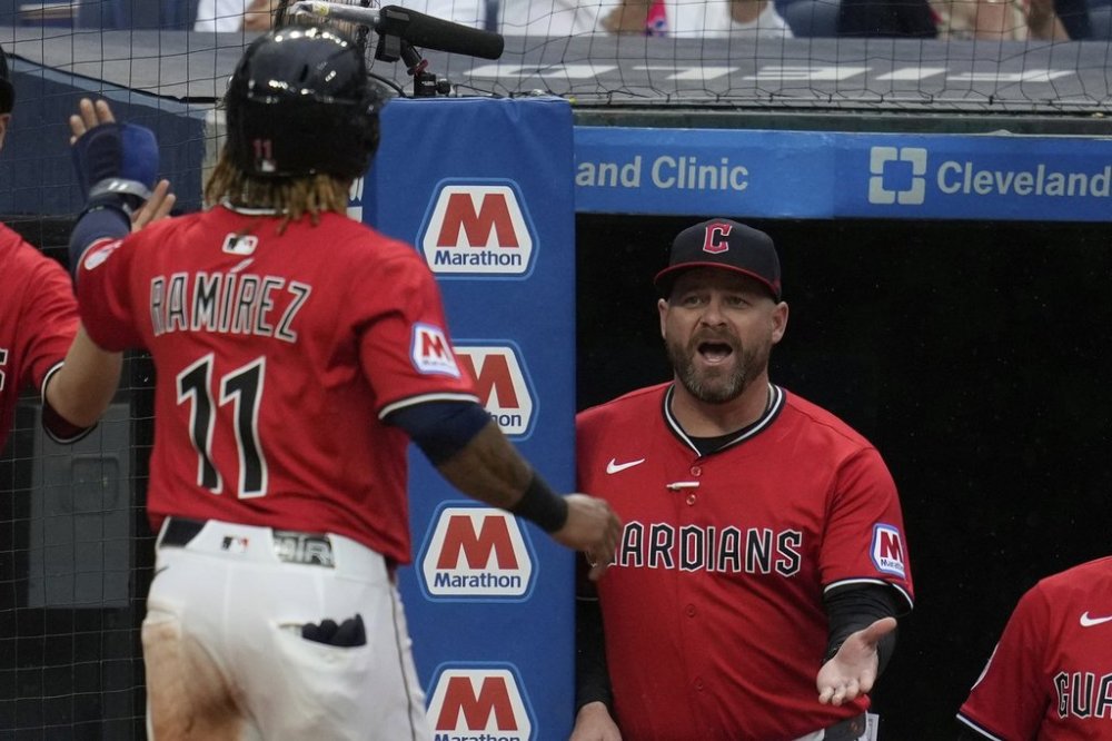 Cleveland Guardians manager Stephen Vogt, right, greets Jose Ramirez (11) as he returns to the dugout after scoring in the sixth inning of a baseball game against the Milwaukee Brewers in Cleveland, Monday, May 12, 2025. (AP Photo/Sue Ogrocki)