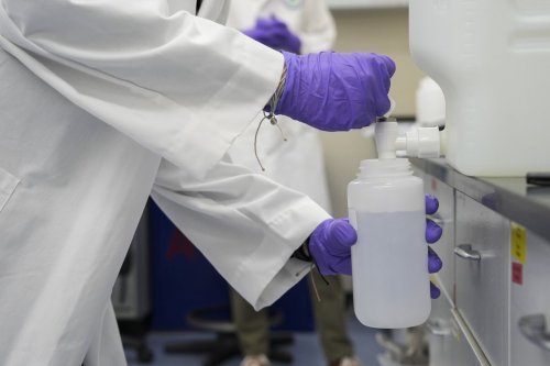 FILE - Logan Feeney pours a water sample with forever chemicals, known as PFAS, into a container for research, April 10, 2024, at a U.S. Environmental Protection Agency lab in Cincinnati. (AP Photo/Joshua A. Bickel, File)