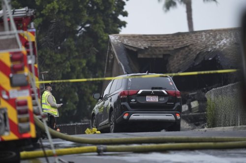 Authorities work the scene where a small plane crashed into a San Diego neighborhood, setting several homes on fire and forcing evacuations along several blocks early Thursday, May 22, 2025. (AP Photo/Gregory Bull)