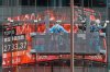 Workers clean the glass window of a building in front of an electronic stock board showing Japan's TOPIX index at a securities firm Friday, May 23, 2025, in Tokyo. (AP Photo/Eugene Hoshiko)
