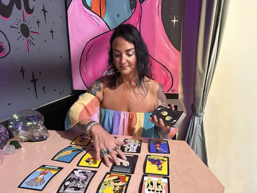 FILE - Ashley Branton lays out tarot cards in the back of her shop, Velvet Witch, in Norfolk, Va., June 13, 2024. (AP Photo/Ben Finley, File)