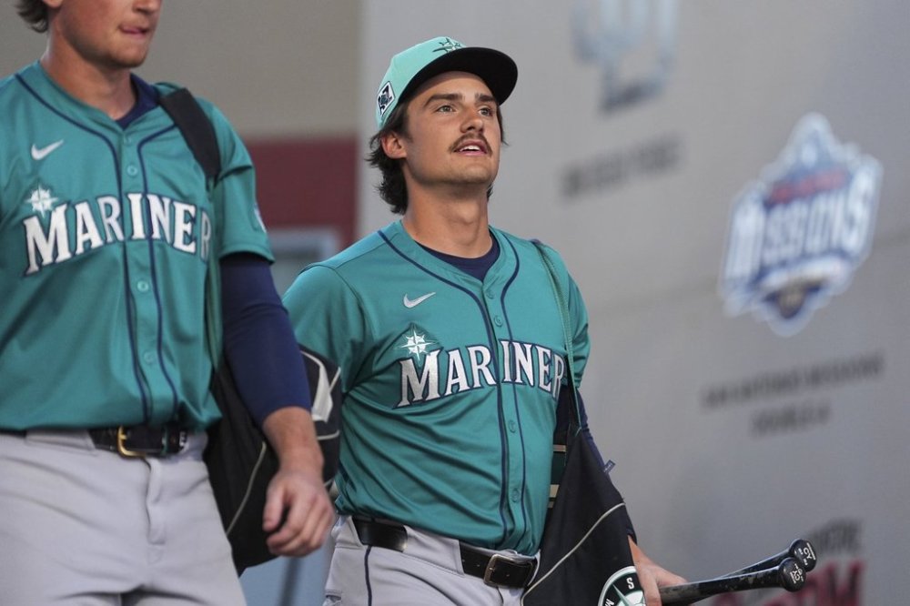 FILE - Seattle Mariners' Cole Young, right, arrives for a spring training baseball game against the San Diego Padres, Friday, Feb. 28, 2025, in Peoria, Ariz. (AP Photo/Lindsey Wasson, File)
