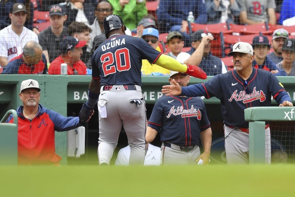 Atlanta Braves' Marcell Ozuna (20) is welcomed to the dugout after scoring on a bases-loaded walk in the fifth inning of a baseball game against the Boston Red Sox, Sunday, May 18, 2025, in Boston. (AP Photo/Steven Senne)