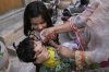 A health worker administers a polio vaccine to a child at a neighbourhood, in Lahore, Pakistan, Monday, May 26, 2025. (AP Photo/K.M. Chaudary)