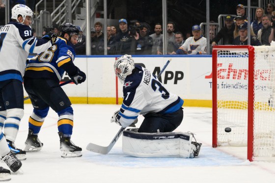 St. Louis Blues left wing Nathan Walker (26) and Winnipeg Jets center Cole Perfetti (91) look on as Jets goaltender Connor Hellebuyck gives up a goal during the second period in Game 6 in St. Louis. (Jeff Le / The Associated Press files)