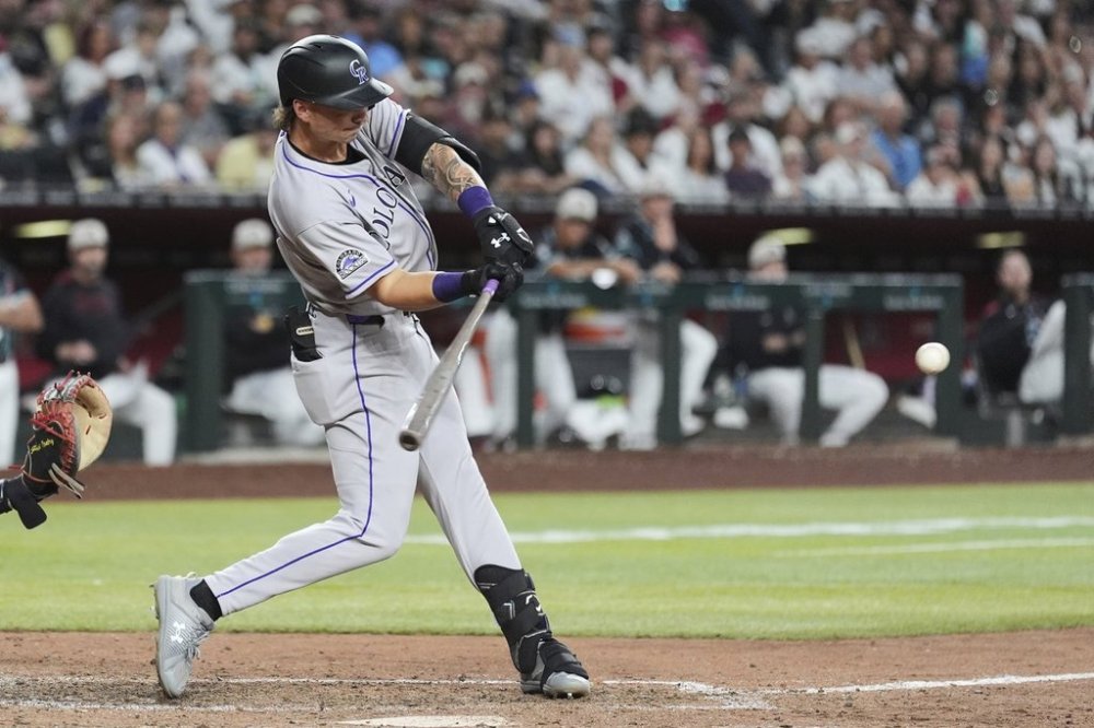 Colorado Rockies' Jordan Beck starts his swing on a two-run home run against the Arizona Diamondbacks during the seventh inning of a baseball game Saturday, May 17, 2025, in Phoenix. (AP Photo/Ross D. Franklin)