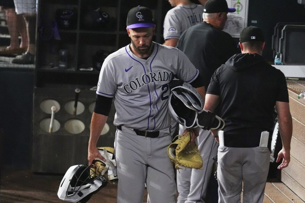 Colorado Rockies catcher Jacob Stallings (25) carries his gear as he walks from the dugout at the end of a baseball game against the Texas Rangers, Wednesday, May 14, 2025, in Arlington, Texas. (AP Photo/LM Otero)