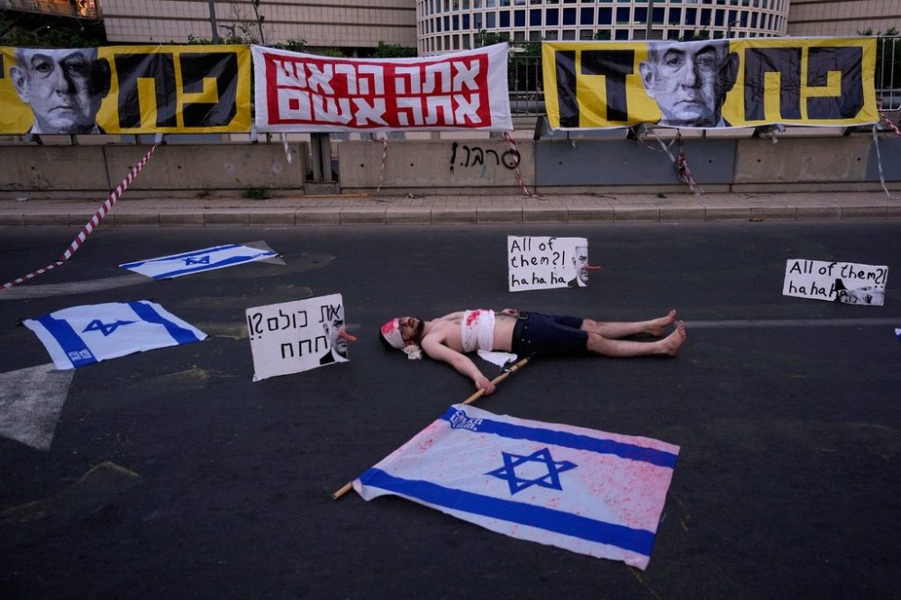 A demonstrator takes part in a performance during a protest demanding the end of the war and immediate release of hostages held by Hamas in the Gaza Strip, and against Prime Minister Benjamin Netanyahu's government in Tel Aviv, Saturday, May 31, 2025. (AP Photo/Ariel Schalit)
