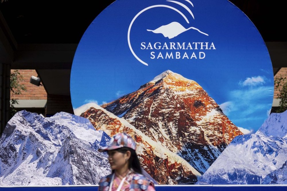 A volunteer awaits to welcome delegates during the inauguration of an environment conference named Sagarmatha Sambaad (Mount Everest Dialogue) at the Soaltee Hotel in Kathmandu, Nepal, Friday, May 16, 2025. (AP Photo/Niranjan Shrestha)estha)