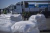 Workers walk past a truck carrying humanitarian aid for the Gaza Strip parked at the offload area of the Kerem Shalom border crossing between Israel and Gaza, southern Israel, Thursday, May 29, 2025. (AP Photo/Ohad Zwigenberg)