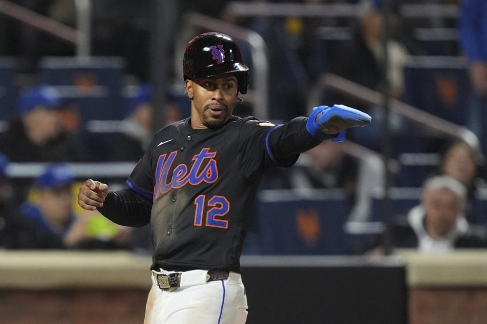 New York Mets' Francisco Lindor (12) gestures to Juan Soto as he scores on a single by Soto during the eighth inning of a baseball game against the Chicago Cubs Friday, May 9, 2025, in New York. (AP Photo/Frank Franklin II)