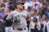 New York Yankees' Aaron Judge heads back to the dugout after touching home plate following his solo home run off Colorado Rockies starting pitcher Kyle Freeland in the first inning of a baseball game Saturday, May 24, 2025, in Denver. (AP Photo/David Zalubowski)
