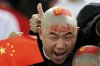 FILE - A Chinese soccer fan cheers for his team before their AFC Asian Cup group A soccer match against Qatar in Doha, Qatar, on Jan. 12, 2011. (AP Photo/Hassan Ammar, File)