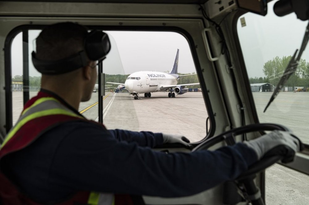 A ground crew looks over at a 42 year old Boeing 737-200 aircraft at Nolinor Aviation in Mirabel, Que., Saturday, May 17, 2025. THE CANADIAN PRESS/Christinne Muschi